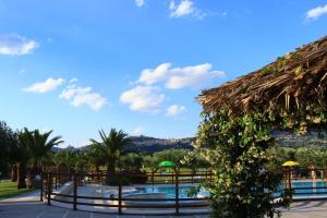 a resort with a swimming pool and palm trees at Agriturismo Il Casale di Monica in Rivotorto
