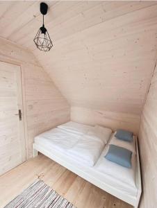 a white bed in a room with a ceiling at Nad Rozlewiskiem in Bobolin