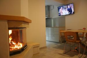 a living room with a fireplace and a table and a television at Apartments Jez in Slap ob Idrijci
