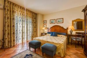 1 dormitorio con 1 cama, mesa y sillas en Il Borgo Country Resort, en Castiglione di Sicilia