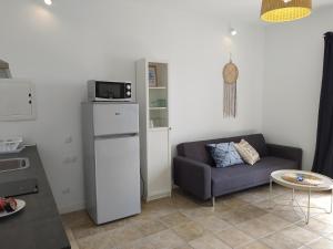 ein Wohnzimmer mit einem Sofa und einem Kühlschrank in der Unterkunft Quintero Suites in San Bartolomé