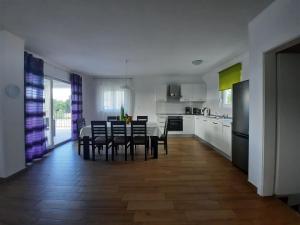 a kitchen and dining room with a table and chairs at VILLA AURA YourCroatiaHoliday in Drenje