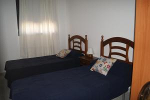 a bedroom with two beds and a window at Apartamentos Porta Mediterranea in Alcossebre