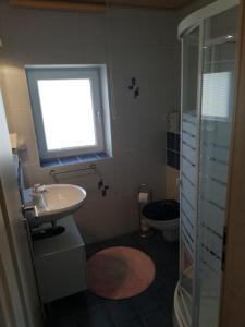 a bathroom with a sink and a toilet and a window at Stadldorf» Ferienwohnung Wagner in Kirchroth