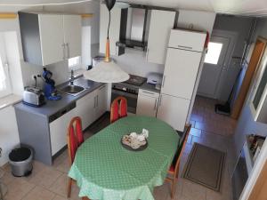 een kleine keuken met een groene tafel en stoelen bij Stadldorf» Ferienwohnung Wagner in Kirchroth