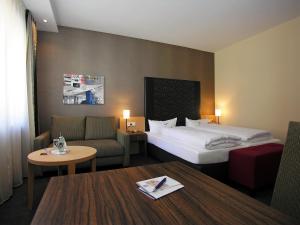 une chambre d'hôtel avec un lit, un canapé et une table dans l'établissement Best Western Hotel Lamm, à Singen