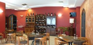 ランダッツォにあるHotel Scrivanoのテーブルと椅子、ワインボトルを用意したレストラン