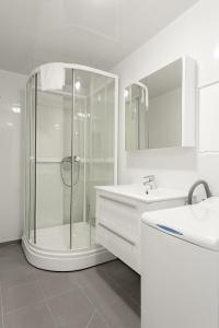 a white bathroom with a shower and a sink at Mo Gjestegård in Mo i Rana