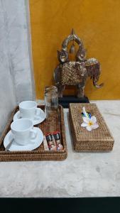 a table with two serving trays with plates and cups at Marin' s Home in Thalang