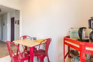 een keuken met een tafel en rode stoelen in een kamer bij Et si on restait en Normandie ? in Caen