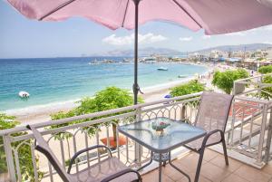 a table and chairs on a balcony with a beach at Chara's Sea View House in Haraki
