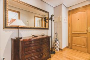 a room with a dresser and a mirror on the wall at Arriola - Local Rentss in San Sebastián