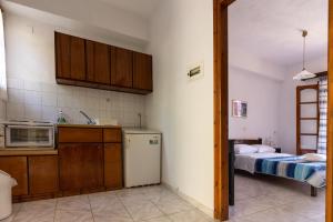 a kitchen with a refrigerator and a bed at Dora Studios in Parga