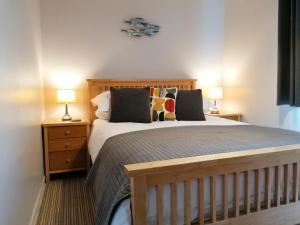 a bedroom with a large bed with two lamps at Schooner Point Guest House in Looe