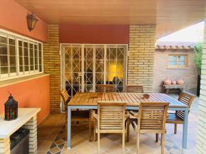 un patio con mesa de madera y sillas en Casa Cambrils Bahia, en Cambrils