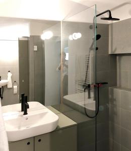 a bathroom with a sink and a glass shower at Gemütliche Wohnung im Herzen von Linz in Linz