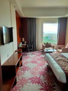 a hotel room with a bed and a large window at Pride Plaza Hotel, Kolkata in Kolkata