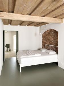 a bedroom with a white bed and a brick wall at Gemütliche Wohnung im Herzen von Linz in Linz