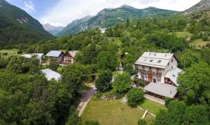 uma vista aérea de uma casa nas montanhas em Hôtel Restaurant Gîtes Les 5 Saisons em Freissinieres