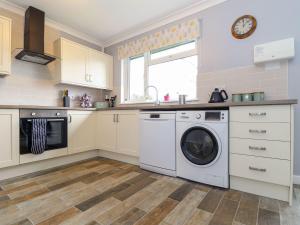 a kitchen with a washing machine and a window at Little Jack's in Callington