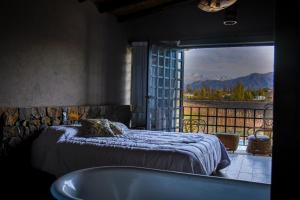 une chambre avec un lit, une baignoire et une fenêtre dans l'établissement CASA DISTINTA, à Mendoza 27 autres photos