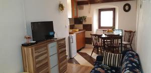 sala de estar con TV y cocina con mesa en Apartment Rafael, en Senj