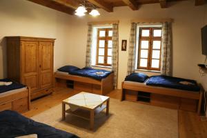 ein Wohnzimmer mit 3 Betten und einem Tisch in der Unterkunft Garábi Udvarház in Garáb