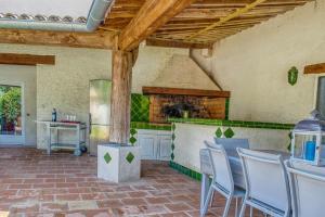 a kitchen with a table and chairs and a stove at Les Vignes de Carcassonne - Piscine et clim in Capendu