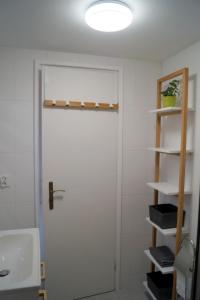a bathroom with a white door and a sink at Pogodny Domek in Mielno +10 photos