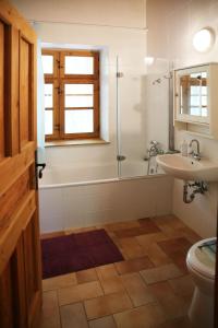 a bathroom with a tub and a toilet and a sink at Garábi Udvarház in Garáb