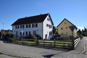 a white house and a yellow house on a street at Ferienhaus Pusteblume in Leutkirch im Allgäu