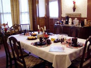 une table avec un tissu de table blanc et de la nourriture dans l'établissement Olde Judge Mansion B&B, à Troy