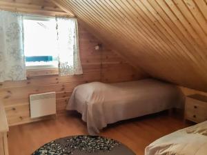 a attic bedroom with two beds and a window at Holiday Home Antin mökki by Interhome in Ylikyro