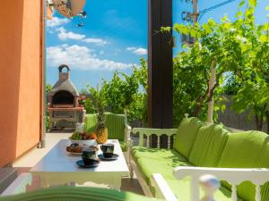 un patio con un sofá y una mesa con comida. en Holiday Home Neja by Interhome en Loborika