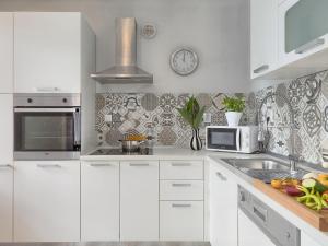 een witte keuken met een wastafel en een magnetron bij Holiday Home Neja by Interhome in Loborika