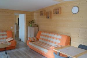 a living room with an orange couch and a table at Pogodny Domek in Mielno