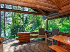 un porche de una cabaña con mesa y sillas en Holiday Home Oravanpesä by Interhome en Tuohikotti