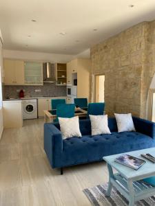 a living room with a blue couch and a table at Villa Caerus in Paphos City