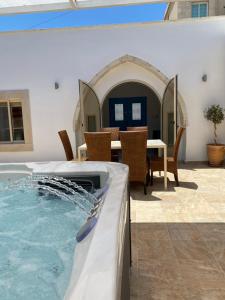 una bañera de hidromasaje en un patio trasero con mesa y sillas en Villa Caerus, en Pafos