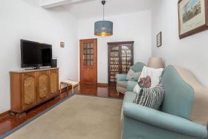 Una sala de estar con dos sillas y un televisor. en Casa Jacarandá, en Silves