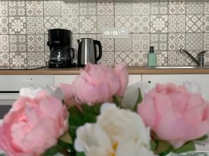a bunch of pink flowers in a kitchen at Otthon a Balatonon Vendégház in Keszthely