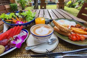 a breakfast table with a cup of coffee and a plate of food at Phor Liang Meun Terracotta Arts in Chiang Mai