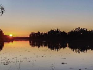 SavonrantaにあるHoliday Home Kuusirinne by Interhomeの木々の水上夕日
