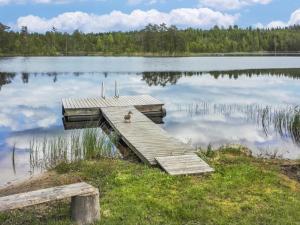 a dog sitting on a dock in the middle of a lake at Holiday Home Kuusirinne by Interhome in Savonranta