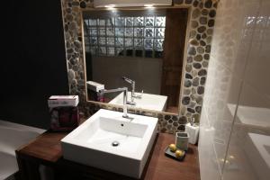 a bathroom with a white sink and a mirror at Les Platanes in Cassis