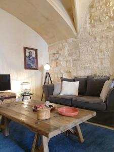 een woonkamer met een bank en een tafel bij Arles Rental-Côté Forum. in Arles
