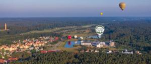 two hot air balloons flying over a small town at Natur Camp Birštonas in Birštonas
