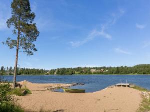 a boat sitting on the shore of a lake at Holiday Home Vuokatticottage f by Interhome in Vuokatti