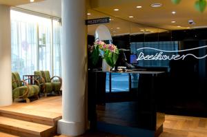 a reception area of a salon with a desk with flowers at Hotel Beethoven Wien in Vienna