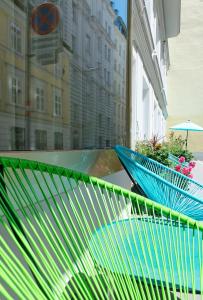 a green park bench sitting in front of a building at Hotel Beethoven Wien in Vienna